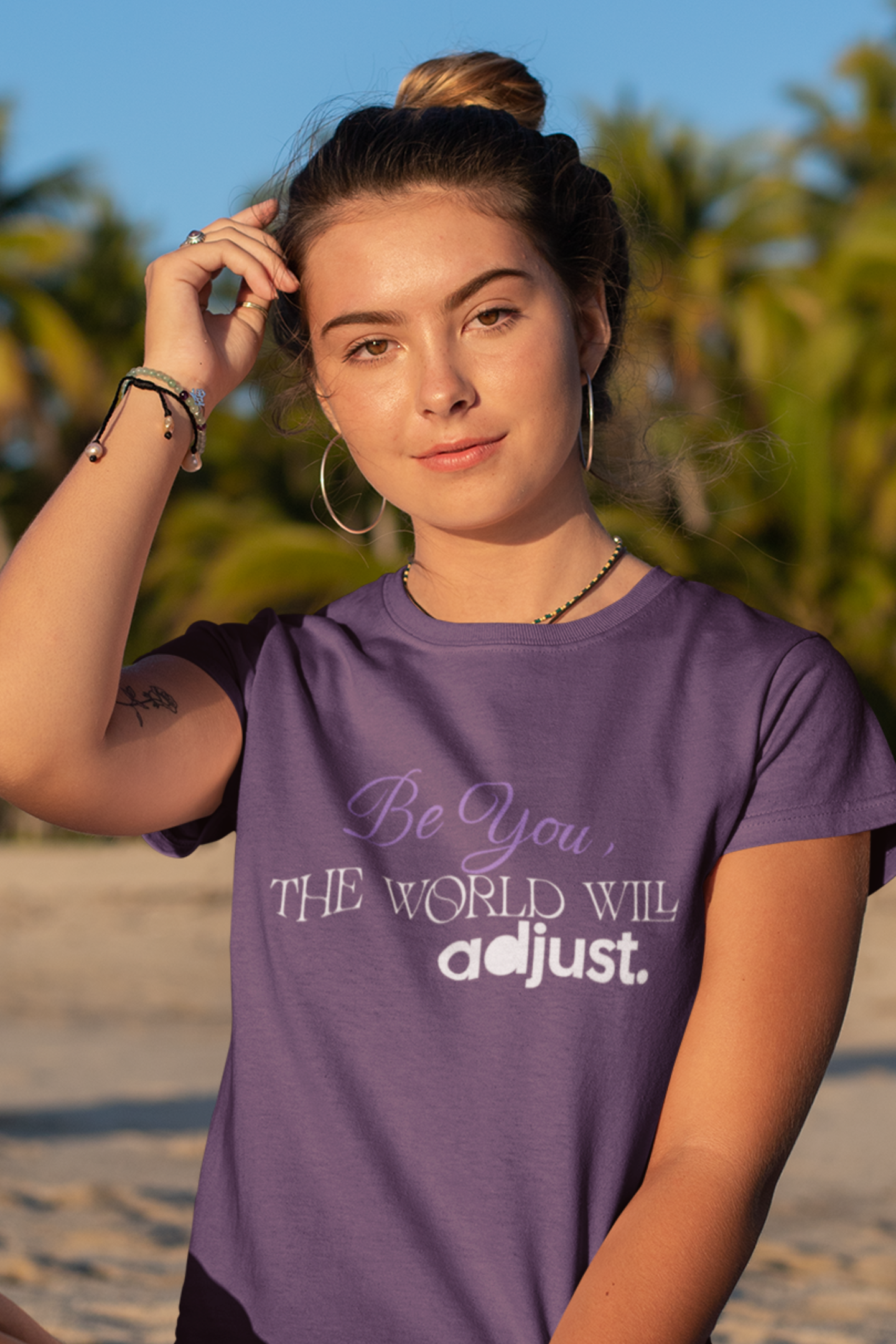 woman-in-beach-wearing-be-you-the-world-will-adjust-tee-purple
