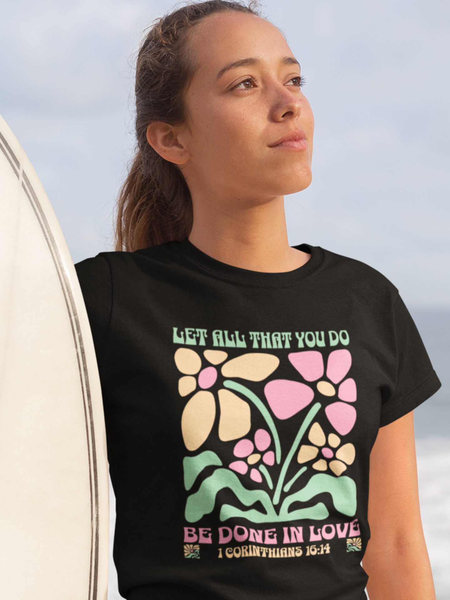woman-in-beach-with-surfboard-wearing-christian-tee-black