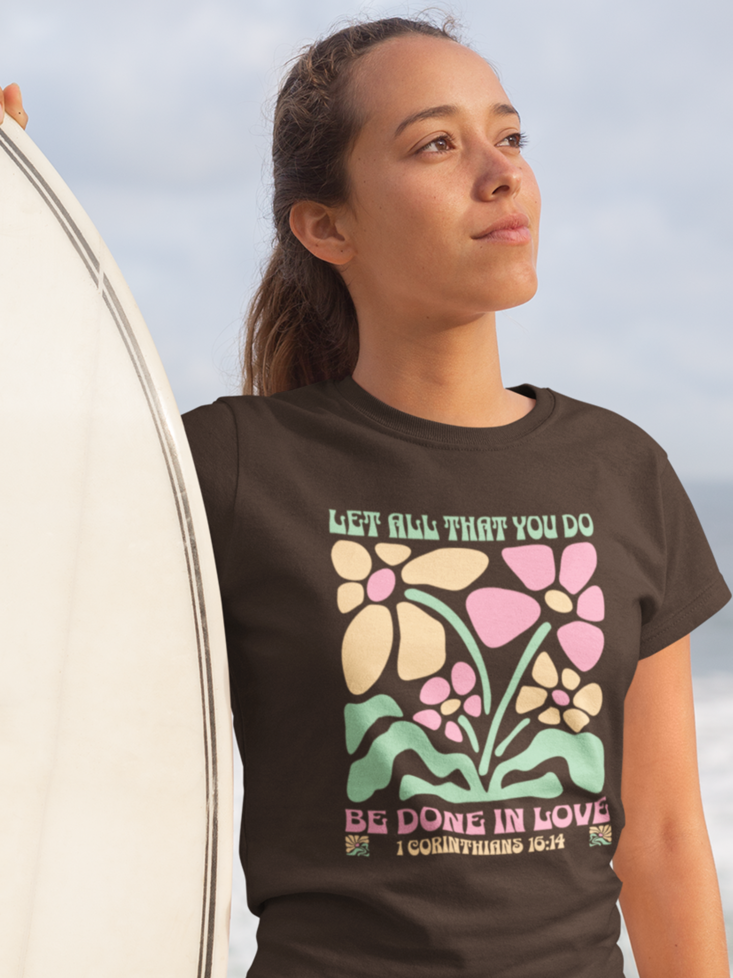 woman-in-beach-with-surfboard-wearing-christian-tee-dark-chocolate