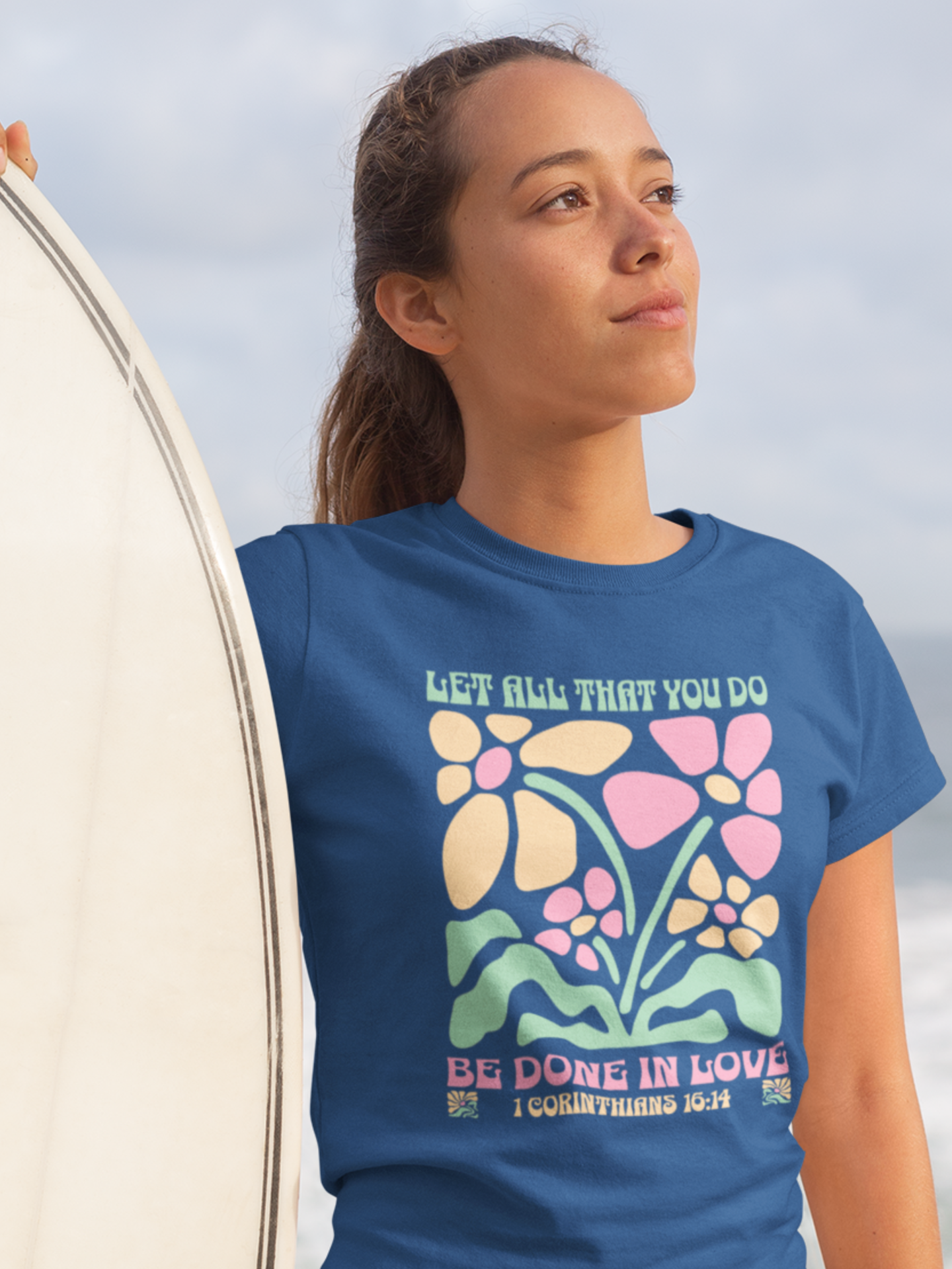 woman-in-beach-with-surfboard-wearing-christian-tee-royal