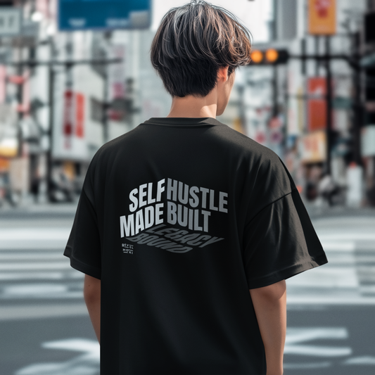 person-wearing-t-shirt-back-of-tee-that-says-self-made-hustle-built-legacy-bound-color-black