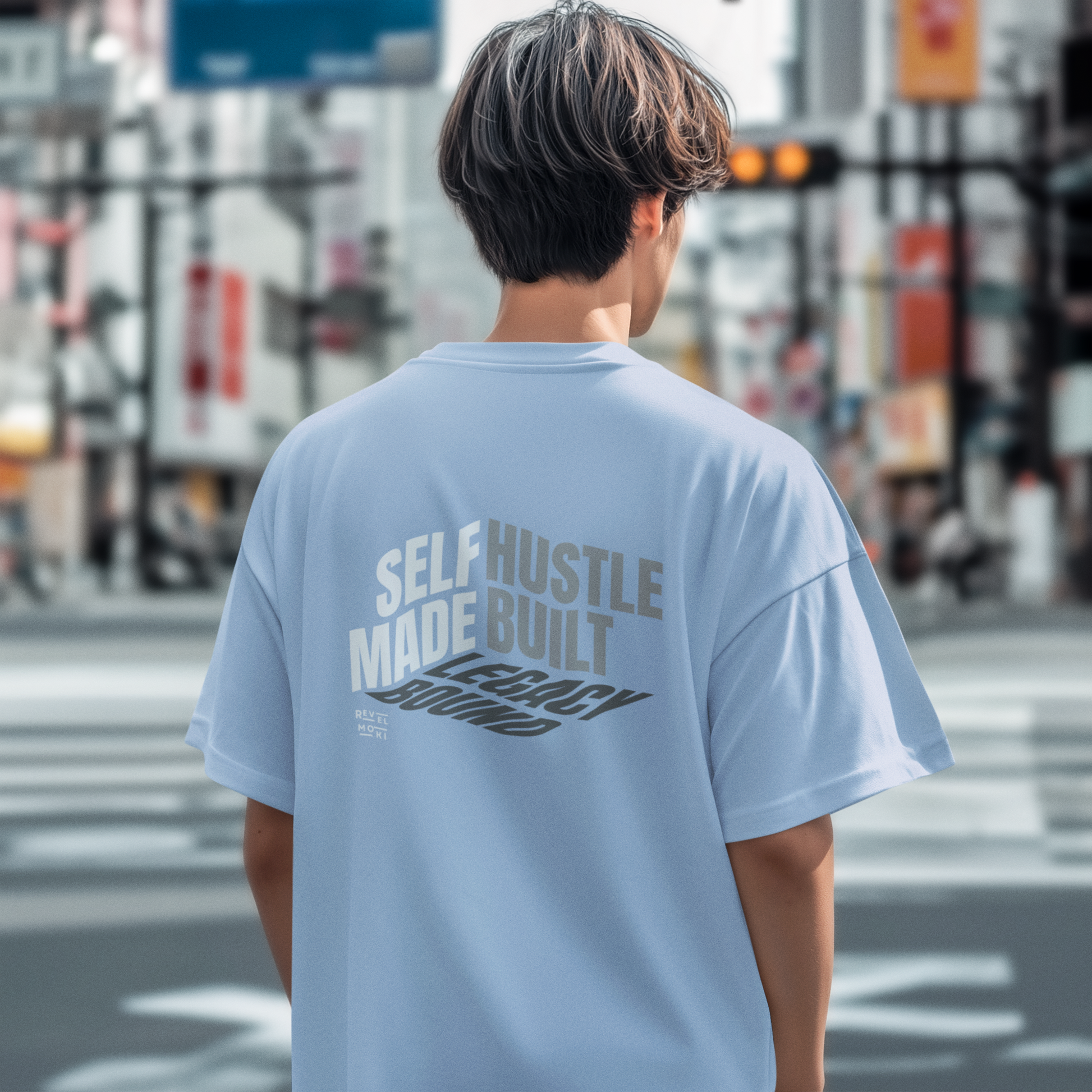 person-wearing-t-shirt-back-of-tee-that-says-self-made-hustle-built-legacy-bound-color-blue
