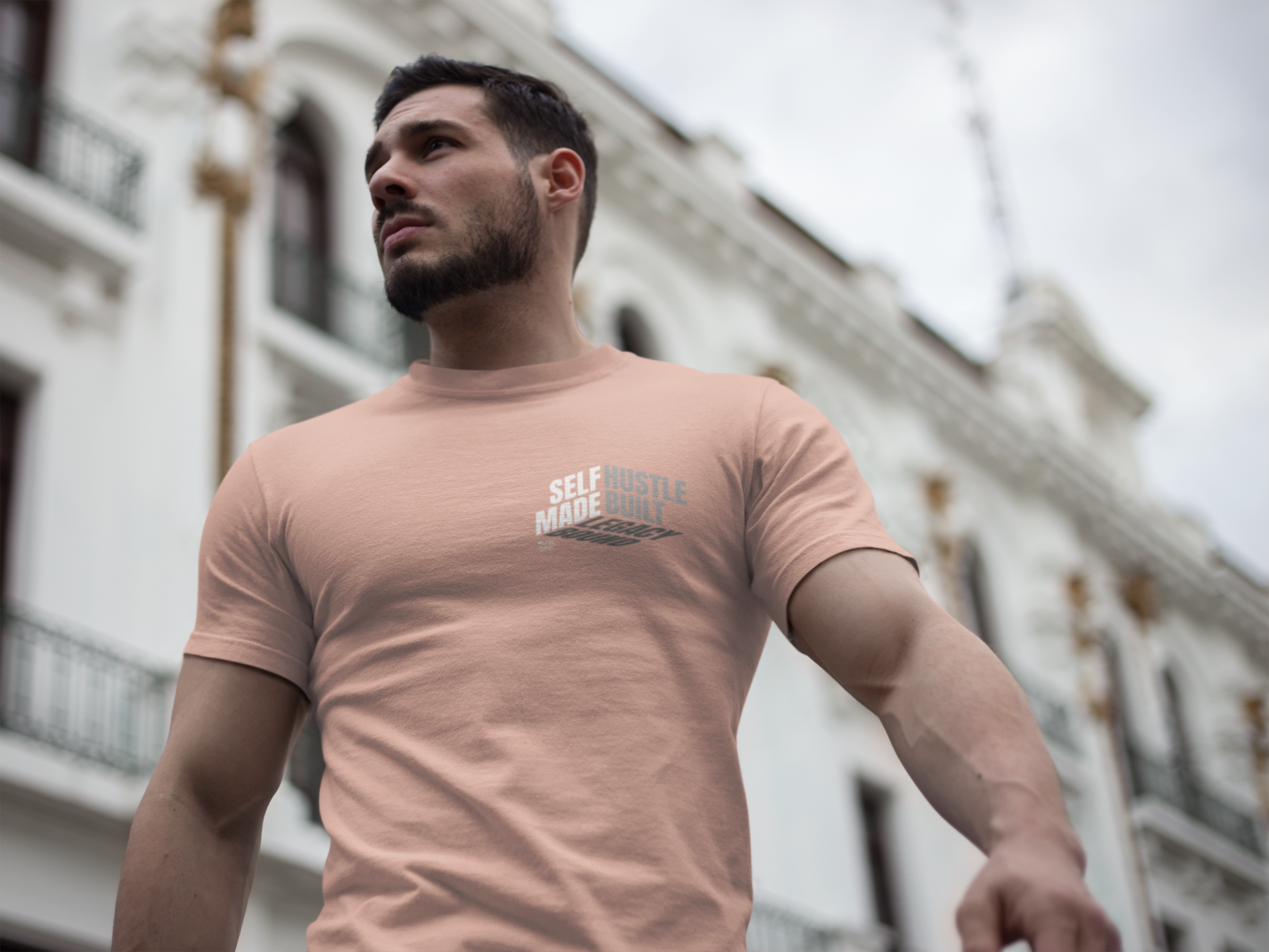 person-wearing-t-shirt-front-of-tee-that-says-self-made-hustle-built-legacy-bound-color-peach