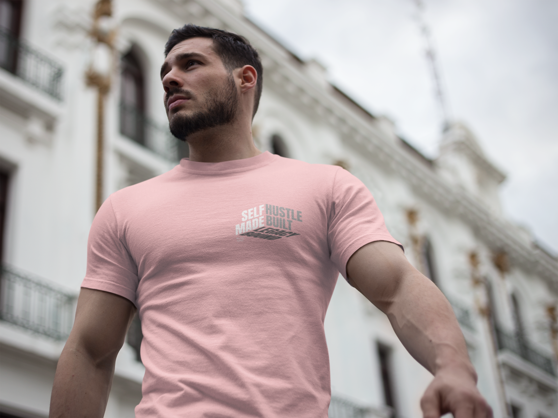 person-wearing-t-shirt-front-of-tee-that-says-self-made-hustle-built-legacy-bound-color-pink