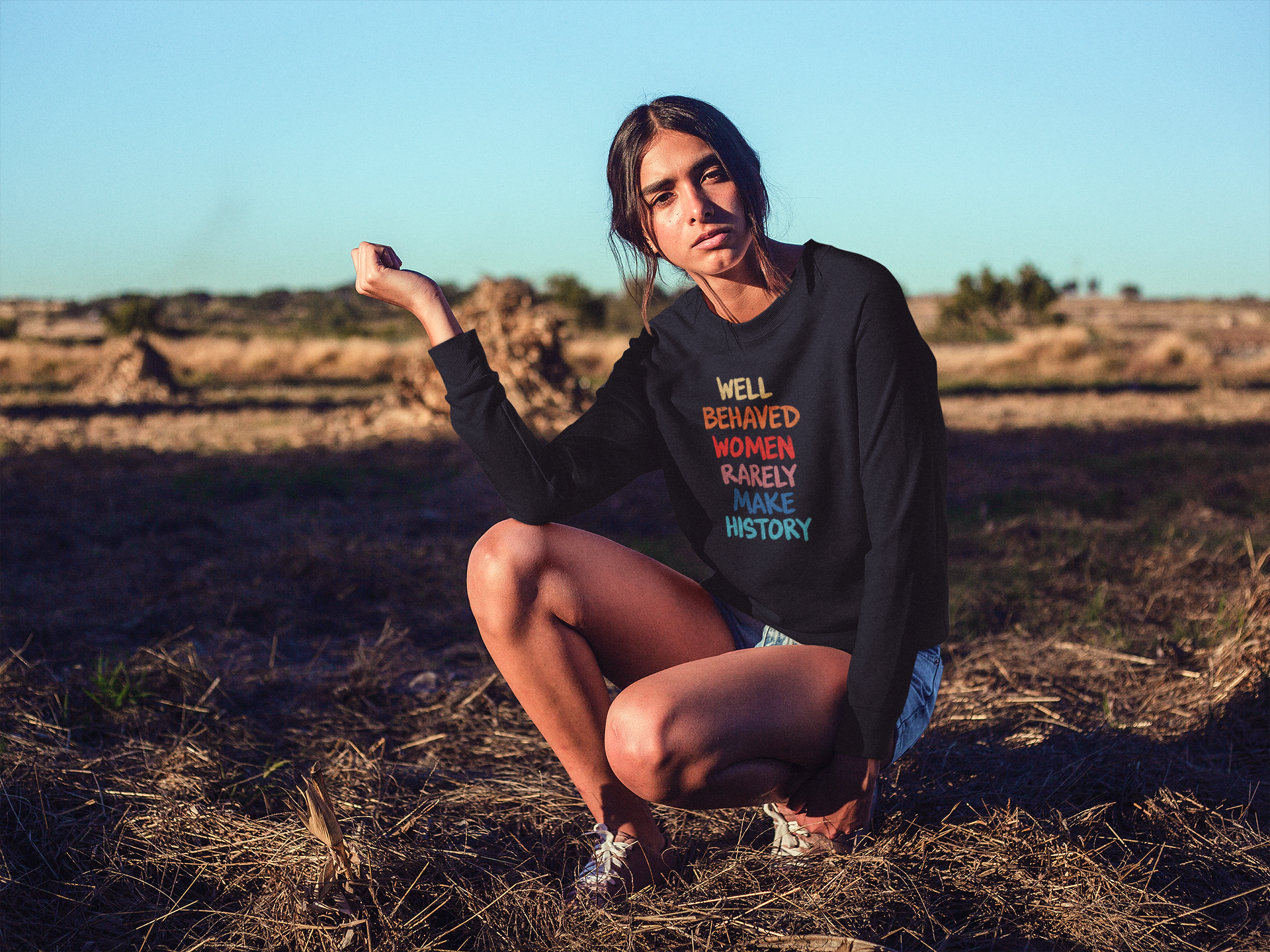 Woman wearing a sweatshirt with a quote in a field