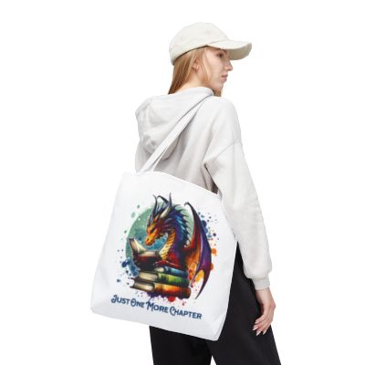 Person wearing a white hoodie with a colorful dragon design and text on a white tote bag.