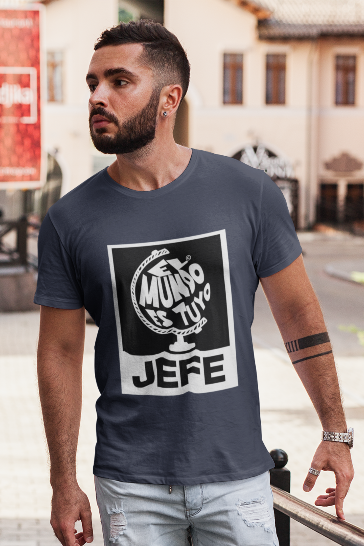 Man wearing a navy blue t-shirt with a graphic design outdoors.