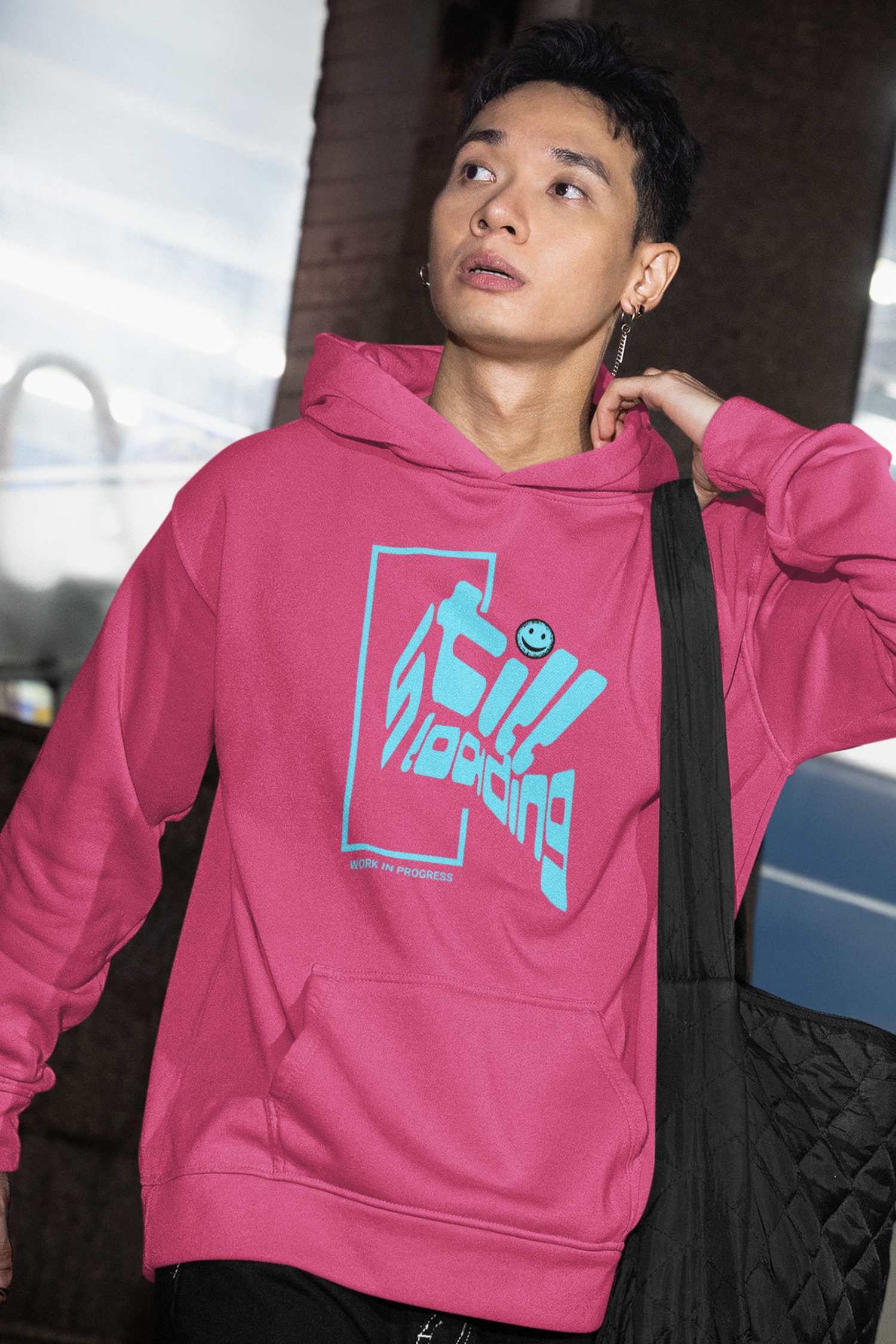 person-wearing-hoodie-with-blue-graphic-design-that-says-still-loading-work-in-progress-color-pink