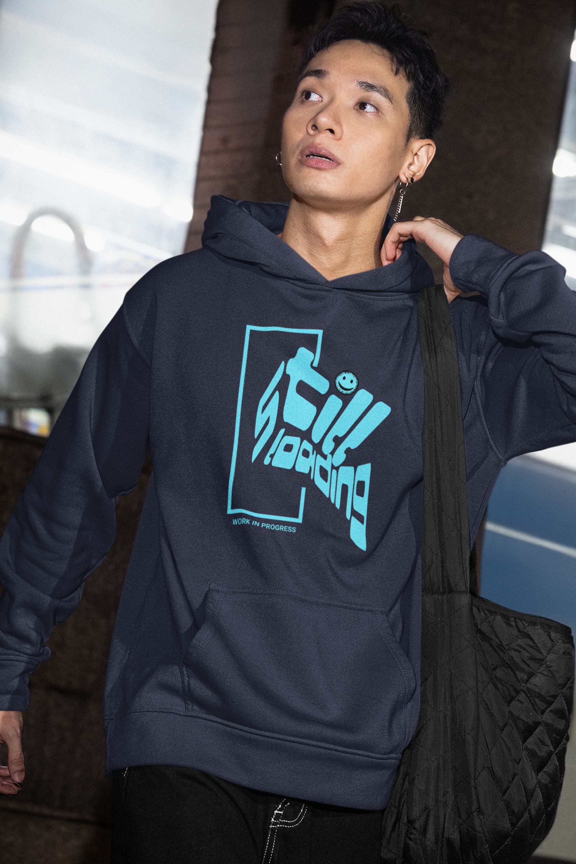 person-wearing-hoodie-with-blue-graphic-design-that-says-still-loading-work-in-progress-color-navy