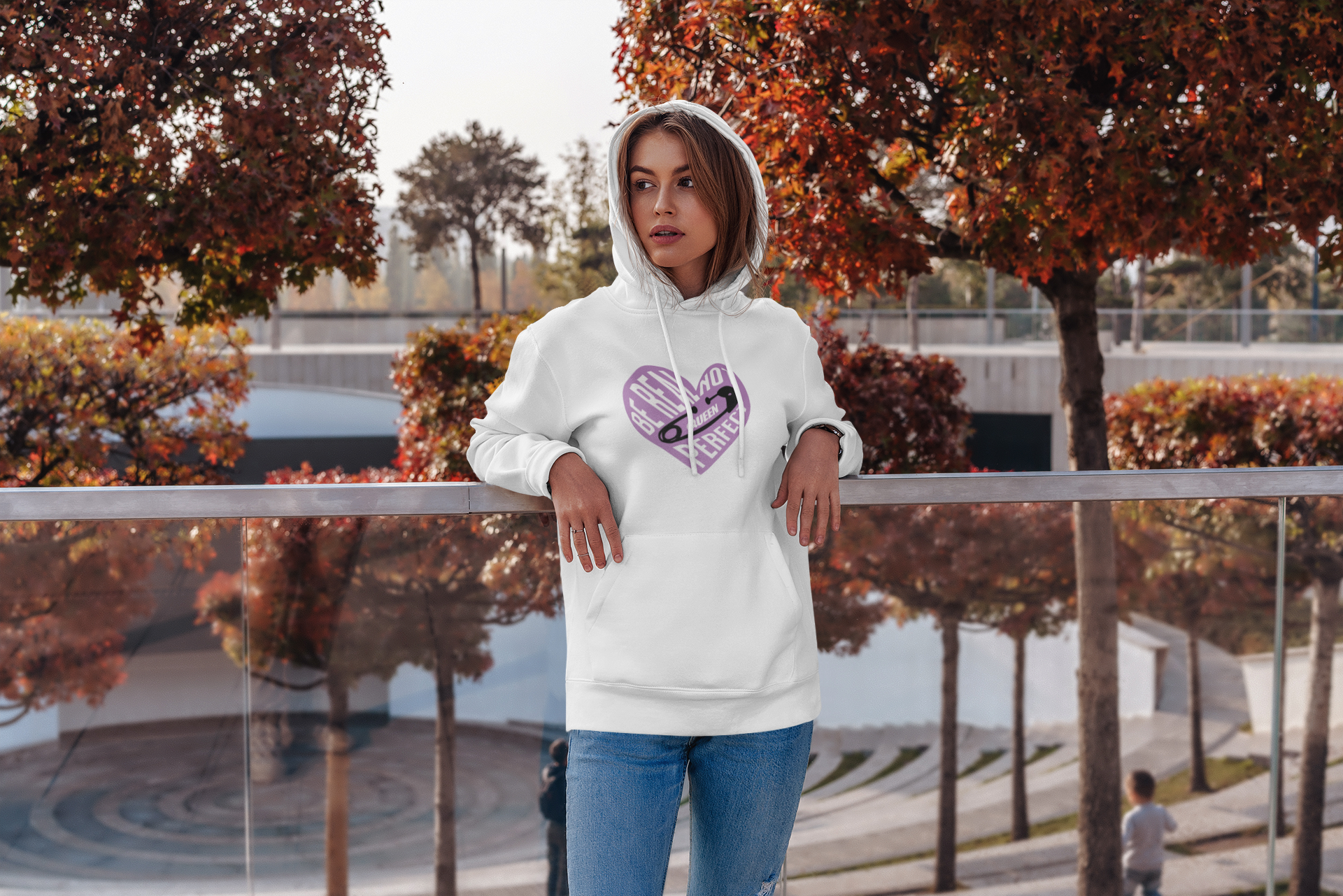 Person wearing a white hoodie with a purple heart design outdoors