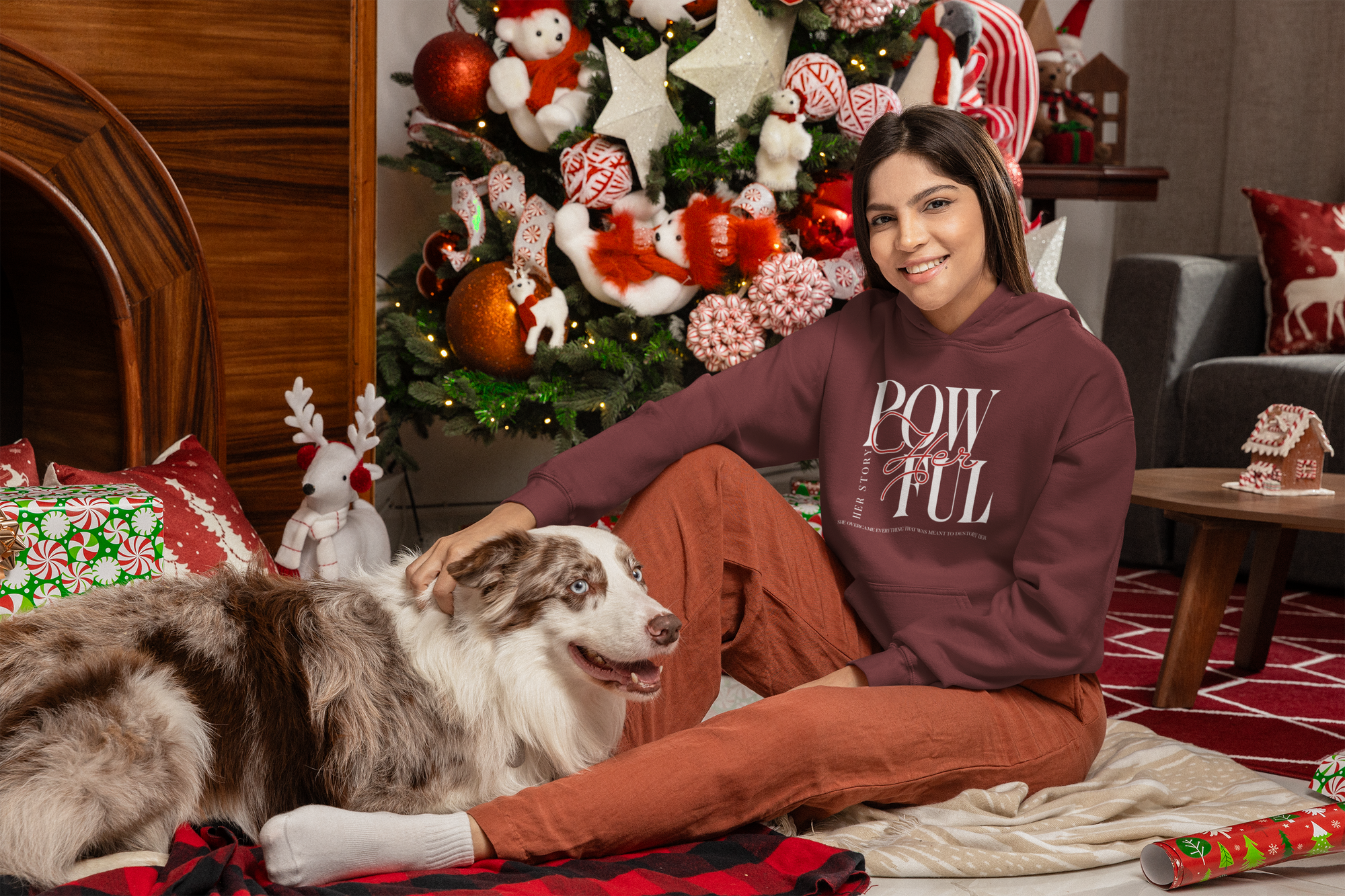 Woman sitting with a dog in a festive living room decorated for Christmas.